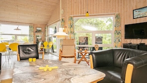 Un salón acogedor con una mesa de mármol, sofá de cuero y televisor.