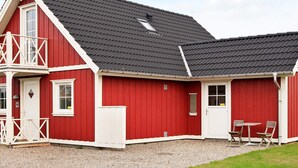 A red building with a balcony, a door, and a window. - 8 Person Holiday Home in Brenderup Fyn (Middelfart)