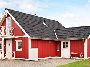 A red building with a balcony, a door, and a window. - 8 Person Holiday Home in Brenderup Fyn (Middelfart)