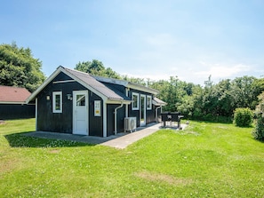 A small, single-story building with a white door and a number '21' sign. - 4 Person Holiday Home in Hovborg (Hovborg)
