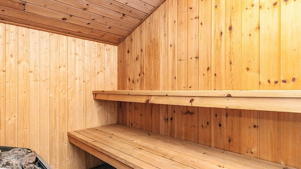 A sauna room with wooden walls and a bench. - 4 Star Holiday Home in Albaek (Aalbaek)