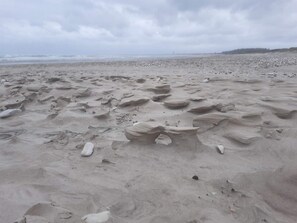 Una playa con rocas dispersas y un cielo nublado.
