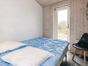 A room with a bed, a chair, and a door leading to an outdoor area.