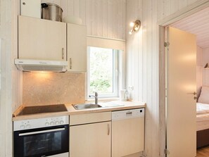 A compact kitchen with a Siemens oven, a dishwasher, and a window providing natural light.