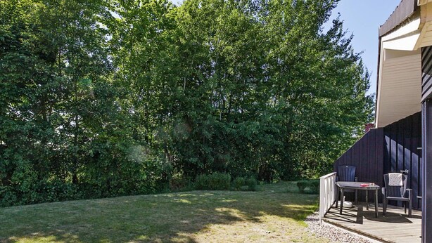 A backyard with a patio area, a table, and two chairs.