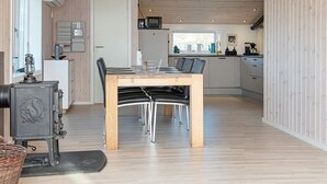 A modern kitchen with a dining area, wooden flooring, and a stove. - 4 Person Holiday Home in Borkop-by Traum (Borkop)