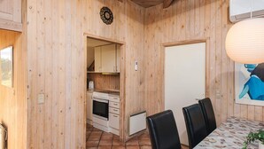 Un intérieur en bois comprenant une cuisine, un coin repas et une porte.