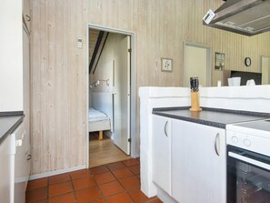 Una cocina compacta con estufa, lavamanos y encimera.