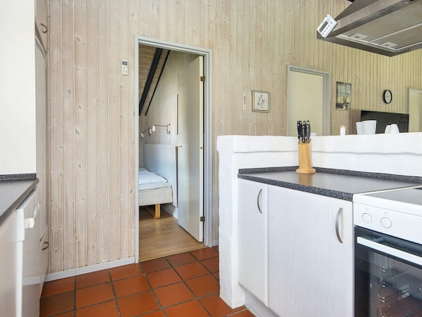 Una cocina compacta con estufa, lavamanos y encimera.