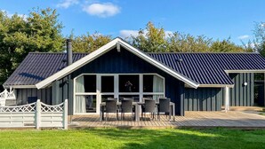 A modern house with a large deck, a covered outdoor seating area, and a chimney. - 4 Star Holiday Home in Sydals (Sydals)