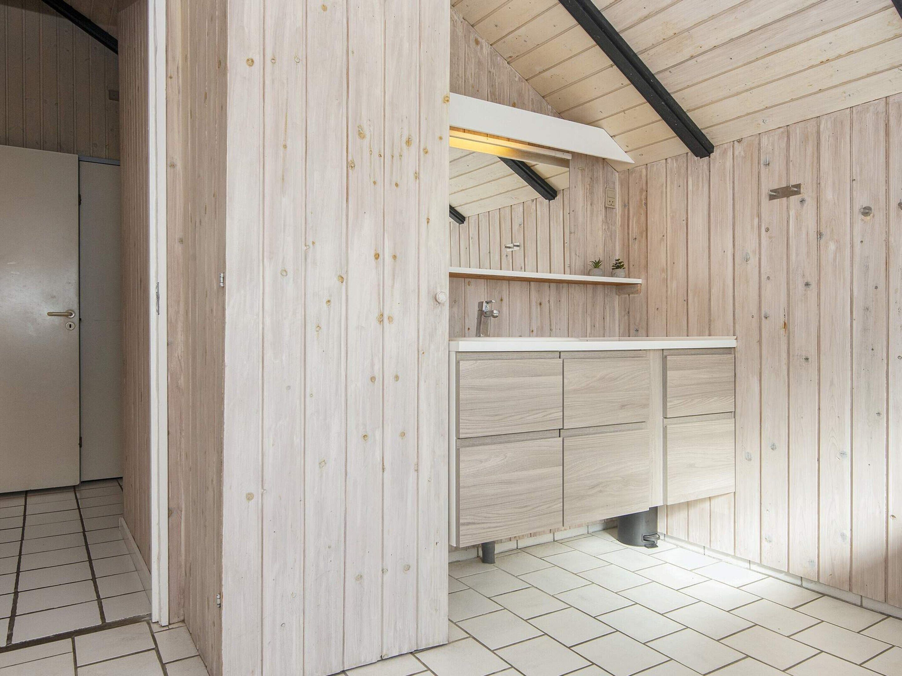 A modern kitchen with wooden cabinetry, a white countertop, and a built-in sink.