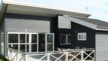 A modern two-story house with a covered patio area.