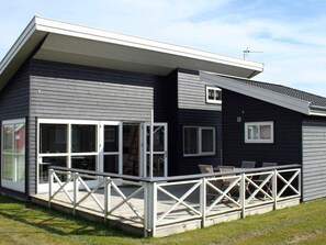A modern house with a covered porch and a small deck. - 6 Person Holiday Home in Gudhjem (Gudhjem)
