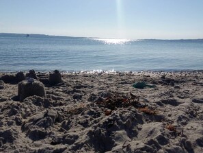 A beach with sand mounds and a clear view of the ocean.