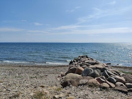A rocky shoreline with a clear view of the sea and a distant horizon.