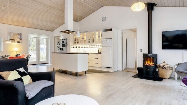 A modern living room with a sofa, a coffee table, and a fireplace. - Family Retreat: Sauna & Fenced Garden (Rodby)