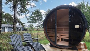 A sauna with a circular exterior, two Adirondack chairs, and a wooden deck. - Family Retreat: Sauna & Fenced Garden (Rodby)