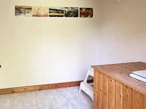 A room with a wooden desk, a white chair, and a wall with four framed pictures. - 4 Person Holiday Home in Braas (Braås)