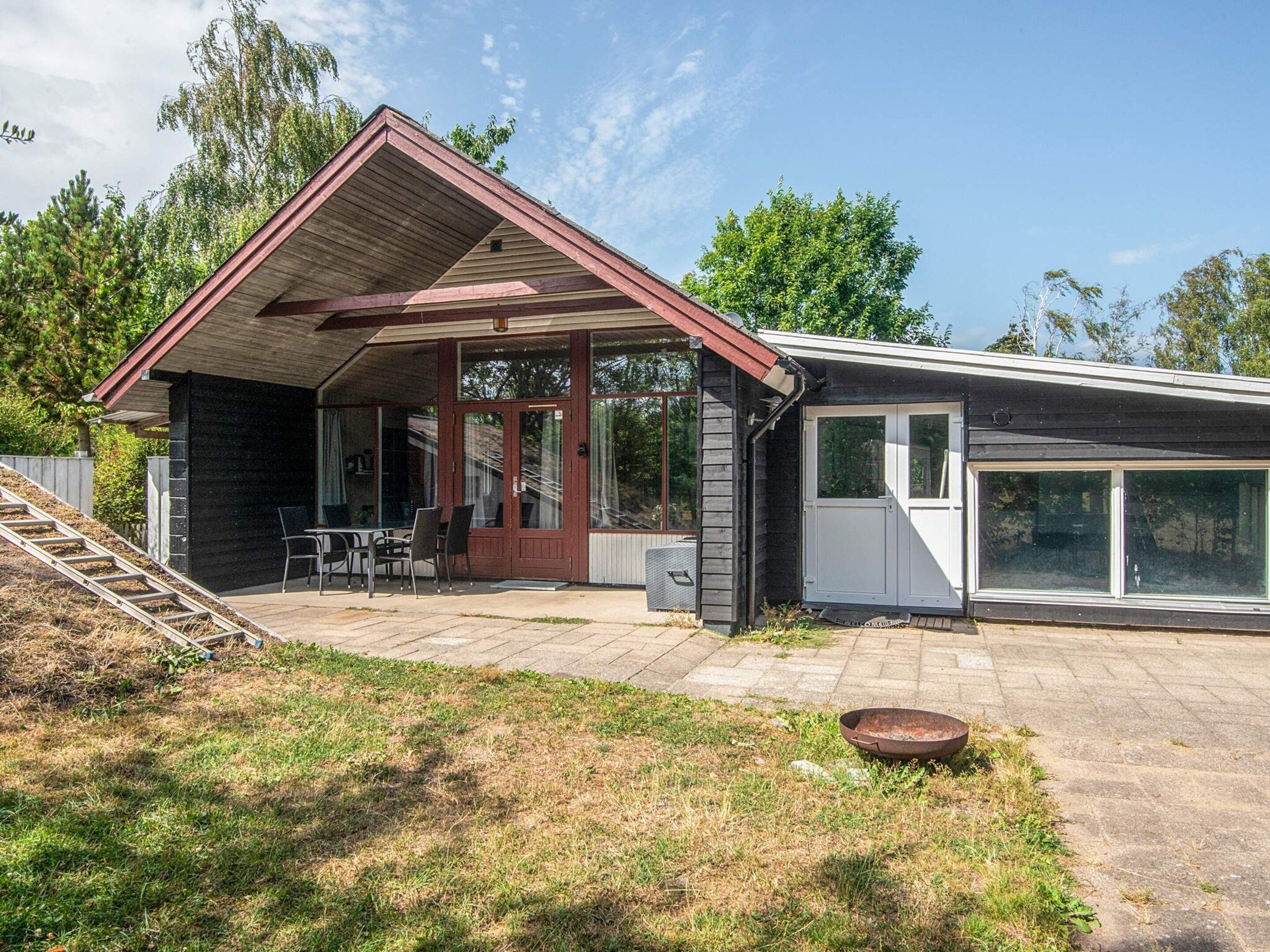 Ein zweistöckiges Haus mit überdachter Terrasse, Eingangstür und Garage.