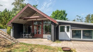 Ein zweistöckiges Haus mit überdachter Terrasse, Eingangstür und Garage.