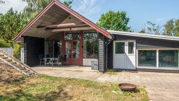 Ein zweistöckiges Haus mit überdachter Terrasse, Eingangstür und Garage.