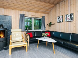 A cozy room with a fireplace, a sofa, a chair, and a table.