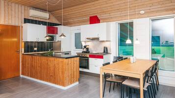 Una cocina moderna con muebles de madera, una isla central y un comedor con mesa y sillas.
