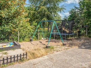 A playground with a swing set and a trampoline. - 4 Star Holiday Home in Ebeltoft (Ebeltoft)