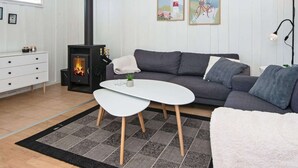 Un salon moderne avec une cheminée, un canapé, une table basse et une commode blanche.