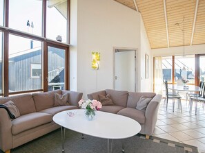 A modern living room with a large window, a white coffee table, and a sofa. - 5 Star Holiday Home in Ulfborg (Ulfborg)
