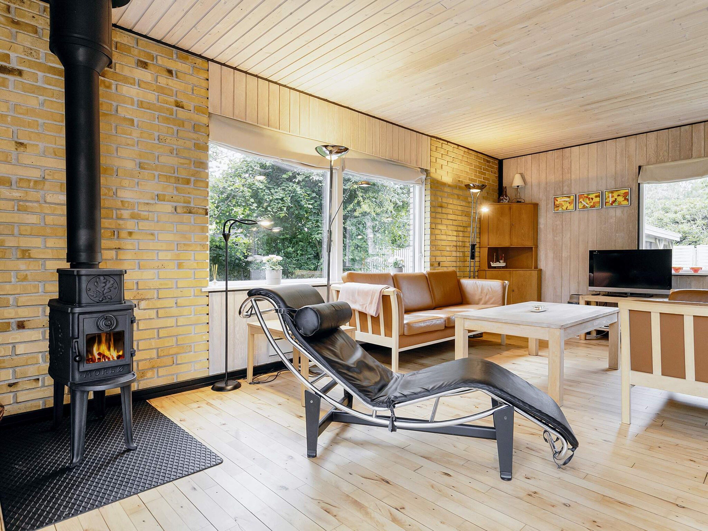 A modern living room with a fireplace, leather sofa, and a television.