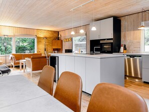 Een moderne keuken met een centraal eiland, houten kastjes en roestvrijstalen apparatuur.
