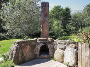 A stone structure with a chimney, surrounded by greenery. - 4 Star Holiday Home in Rodby (Rodby)