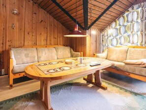 Ambiente in legno con un divano, un tavolo e una parete decorata.