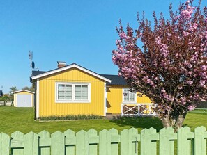 A yellow house with a white window and a number '8' on the side.