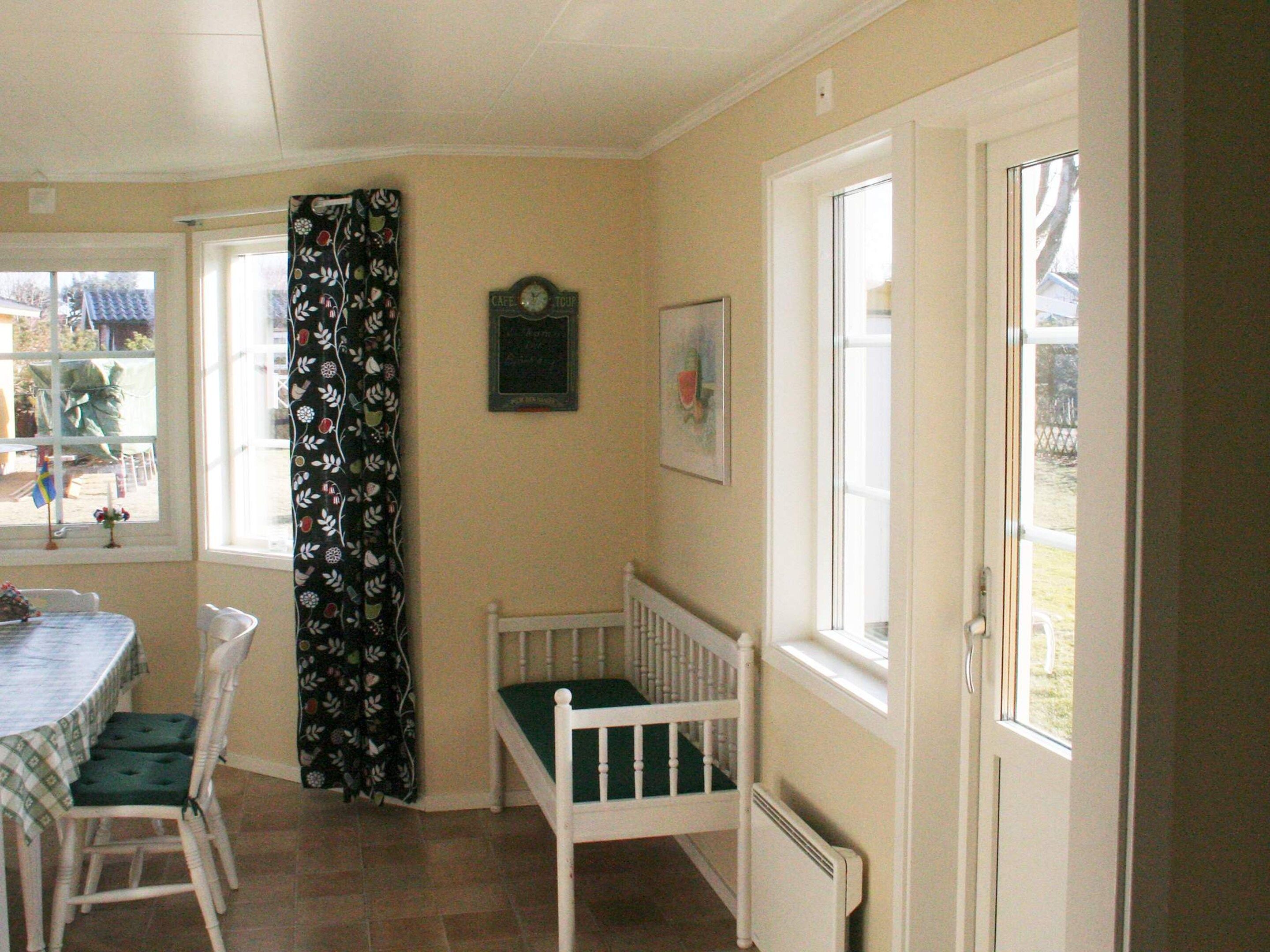 A dining area with a table and chairs, a window with a view, and a door leading outside.