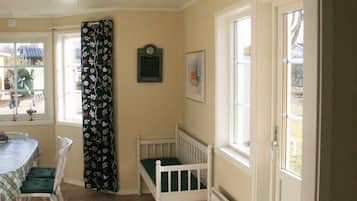 A dining area with a table and chairs, a window with a view, and a door leading outside.