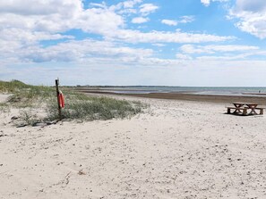 Ein Strand mit einer Rettungswache und einem Picknicktisch.