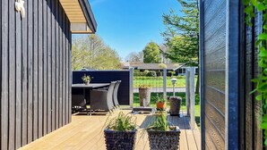 A wooden deck with outdoor furniture and potted plants. - 4 Star Holiday Home in Nordborg (Nordborg)