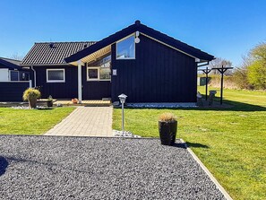 A modern house with a dark exterior, a paved driveway, and a well-maintained lawn. - 4 Star Holiday Home in Nordborg (Nordborg)