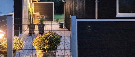A fenced outdoor area with potted plants and a patio.