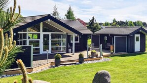 A modern two-story house with large windows, a wooden deck, and a stone pathway leading to the entrance. - 4 Star Holiday Home in Nordborg (Nordborg)