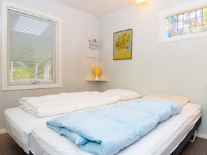 A bedroom with two beds, a window with blinds, a wall-mounted light, and a painting. - 4 Person Holiday Home in Ans By (Ans)