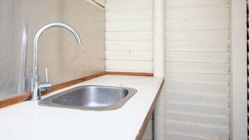 A small kitchen with a single stainless steel sink and a faucet.