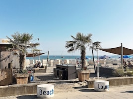 Un área de descanso junto a la playa con asientos y vistas al mar.
