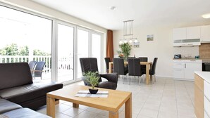 A modern apartment with a living area, dining space, and kitchen. - Holiday Home in GroÃŸenbrode (Grossenbrode)