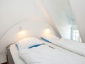 Ein Zimmer mit zwei Betten, einer gewölbten Decke und einem Fenster.