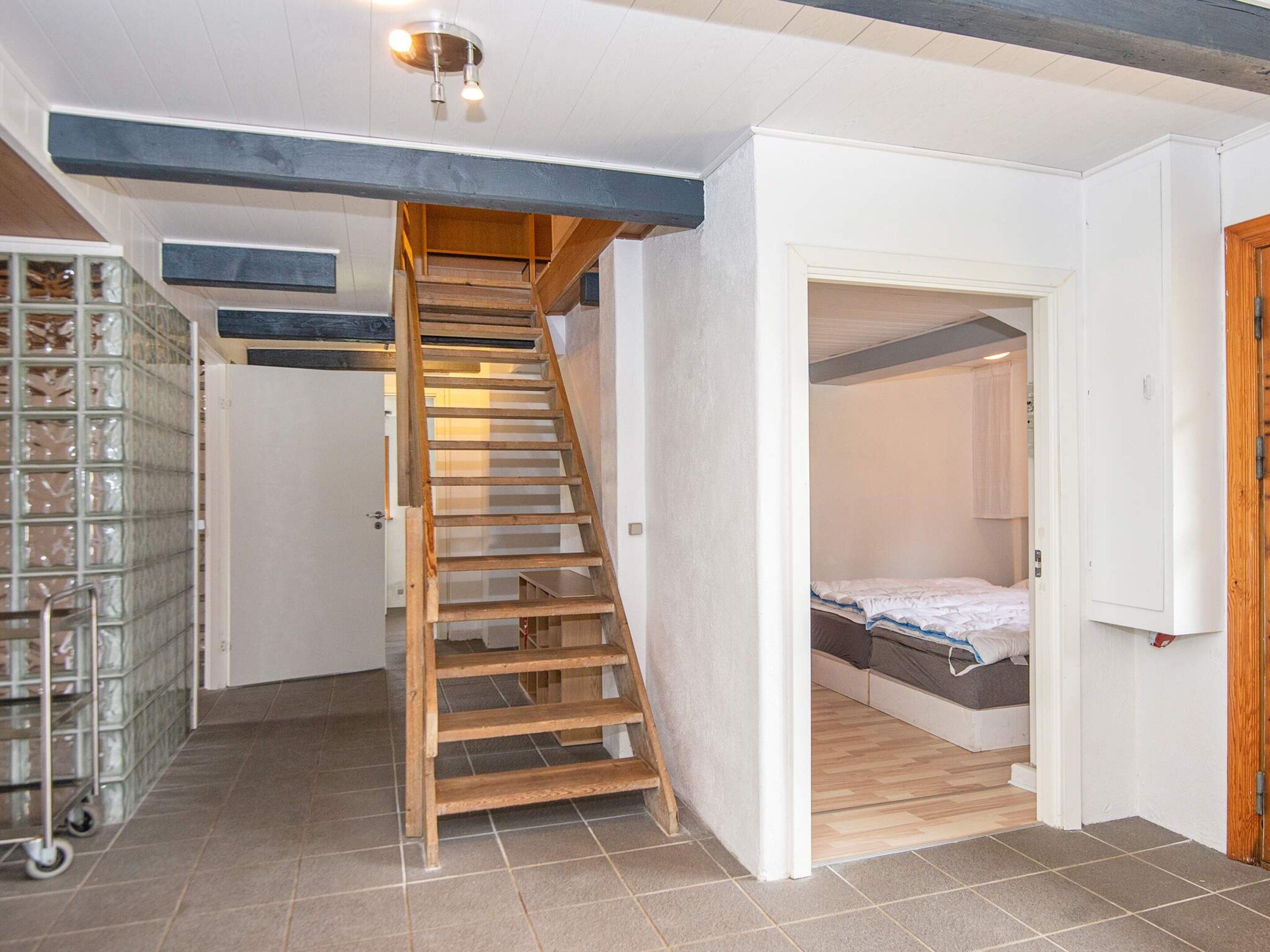 Una escalera conduce a un dormitorio en el altillo, con una cama y una pequeña zona de estar.