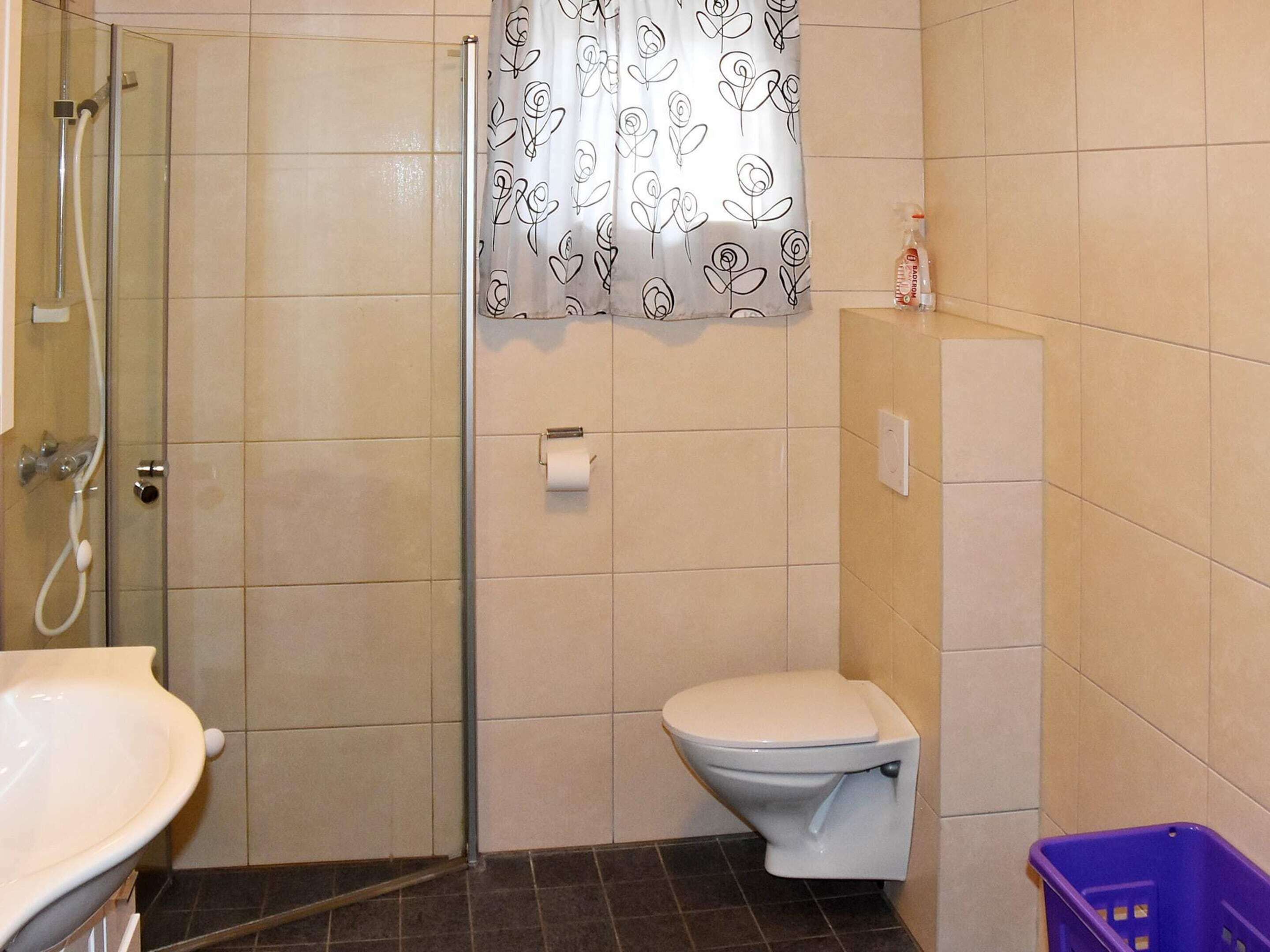 Un baño con ducha, inodoro y lavabo.