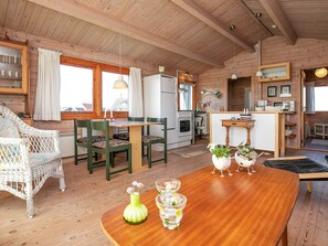 A cozy cabin interior with a dining area, kitchen, and a small living space. - 8 Person Holiday Home in Harboore (Harboore)